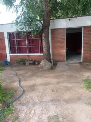 a garage with a blue hose in front of a building at Depto Villa Soto in Mina Clavero