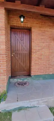 a large wooden door on a brick building at Cabaña El Molle - Los Nogales in Mina Clavero