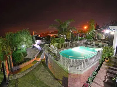 a swimming pool in a yard at night at Cabañas La Morada de Tanti in Tanti