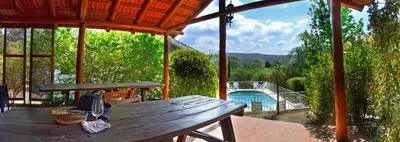 a wooden picnic table on a porch with a view at Cabañas La Morada de Tanti in Tanti