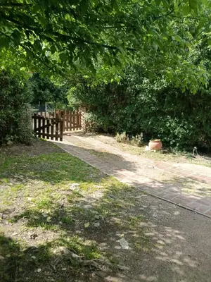 a wooden fence next to a path in a park at Das Kleine Nest in Villa General Belgrano