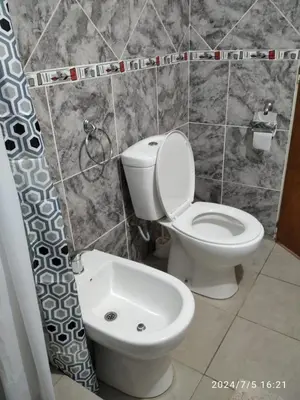 a bathroom with a toilet and a shower curtain at Aguaribay Cabañas in Arroyo de Los Patos