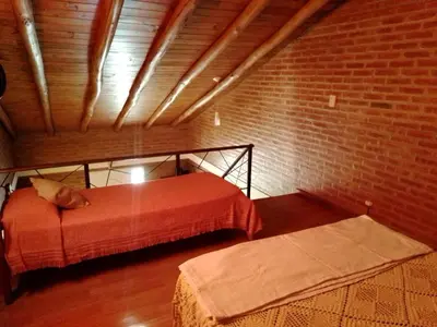 a room with a bed and a brick wall at Aguaribay Cabañas in Arroyo de Los Patos