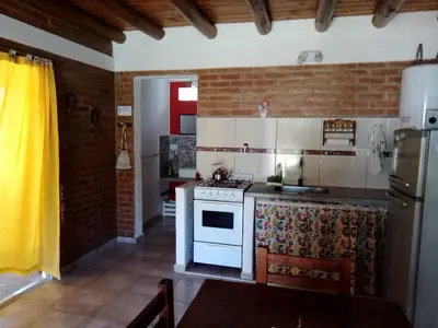 a kitchen with a white stove and a sink at Aguaribay Cabañas in Arroyo de Los Patos