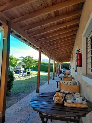 a wooden picnic table under awning on a patio at Posada L'Agustina in Nono