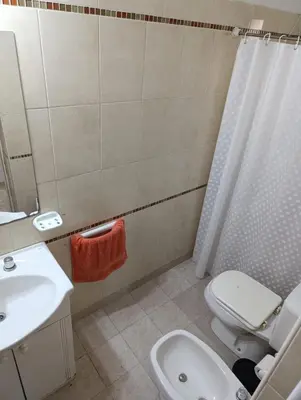 a bathroom with a white toilet and a sink at Dpto Centro de Carlos Paz - Avellana in Villa Carlos Paz