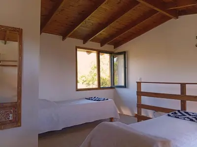 a bedroom with two beds and a window at Suspiro Serrano in Villa General Belgrano