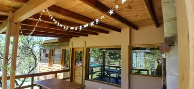 a house with a porch with a view of a pool at Suspiro Serrano in Villa General Belgrano