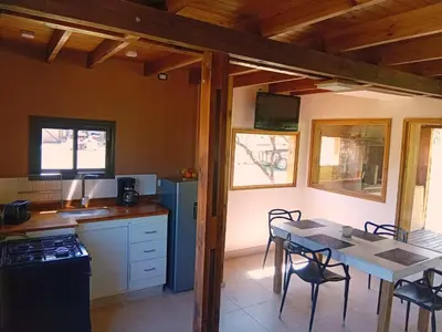 a kitchen with a table and a kitchen with a table and chairs at Suspiro Serrano in Villa General Belgrano