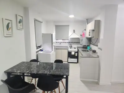 a kitchen with a table and chairs in it at Traslasierra Champaquí Deptos in Villa Dolores