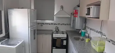 a small kitchen with a sink and a refrigerator at Traslasierra Champaquí Deptos in Villa Dolores