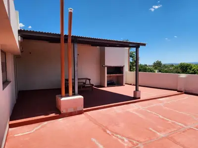 a patio with a table on top of a house at Traslasierra Champaquí Deptos in Villa Dolores