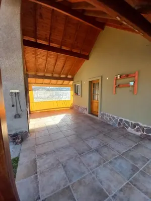 an open living room with a wooden ceiling at R y C Nuestro Lugar in Villa General Belgrano
