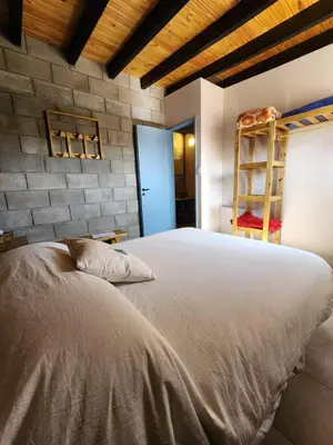 a large bed in a bedroom with a brick wall at La Bimba Cabañas en Cabalango in Cavalango