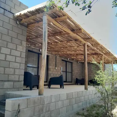 a patio with a wooden pergola on a building at La Bimba Cabañas en Cabalango in Cavalango