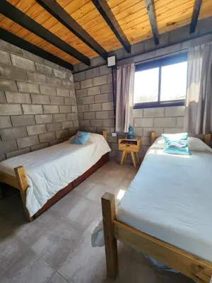 a bedroom with two beds in a brick wall at La Bimba Cabañas en Cabalango in Cavalango