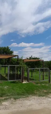 a metal gate in a field with a fence at La Bimba Cabañas en Cabalango in Cavalango