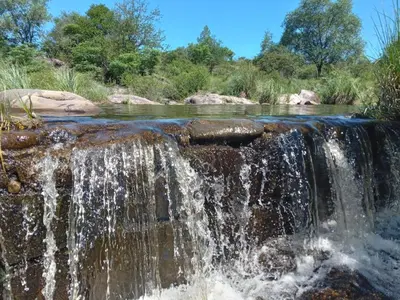 a waterfall on a river with trees in the background at La Bimba Cabañas en Cabalango in Cavalango