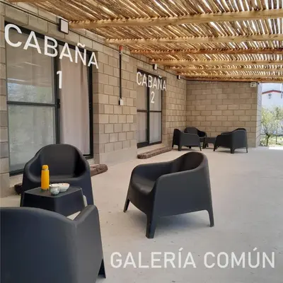 a group of chairs and tables in front of a building at La Bimba Cabañas en Cabalango in Cavalango