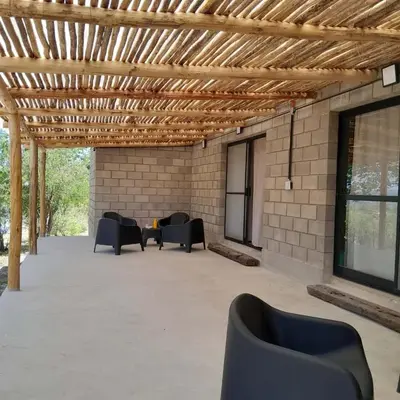 a patio with couches and chairs under a wooden ceiling at La Bimba Cabañas en Cabalango in Cavalango