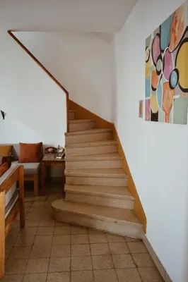 a staircase in a room with a couch and a painting at Casa Revol céntrica ideal familias-grupos hasta 12 pax in Cordoba