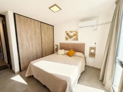 a bedroom with a bed and a large window at PASEO QUATTRO Alquileres in Villa Carlos Paz