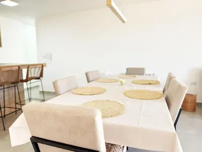 a table with chairs and a white table cloth at PASEO QUATTRO Alquileres in Villa Carlos Paz