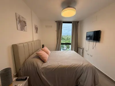 a bedroom with a bed and a tv and a window at PASEO QUATTRO Alquileres in Villa Carlos Paz