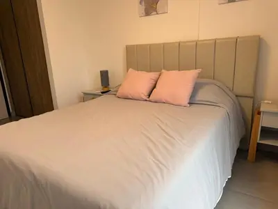 a bedroom with a bed with two pink pillows at PASEO QUATTRO Alquileres in Villa Carlos Paz