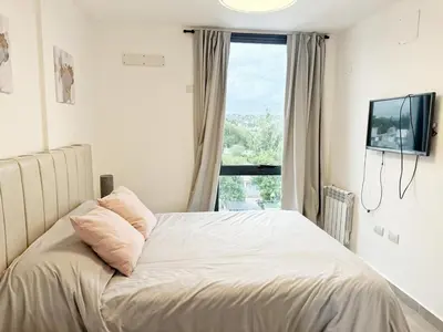 a bedroom with a bed with a large window at PASEO QUATTRO Alquileres in Villa Carlos Paz
