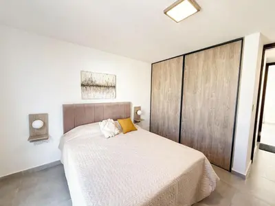a bedroom with a large bed with a wooden headboard at PASEO QUATTRO Alquileres in Villa Carlos Paz
