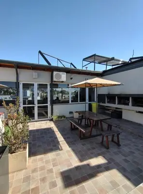 a patio with two picnic tables and an umbrella at Miralejos I Carlos Paz in Villa Carlos Paz