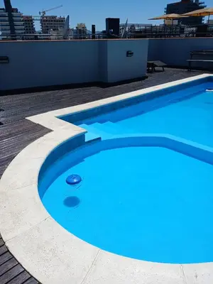 a large blue swimming pool on top of a building at Miralejos I Carlos Paz in Villa Carlos Paz