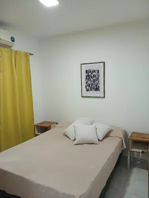 a bedroom with a large bed with a green curtain at Miralejos I Carlos Paz in Villa Carlos Paz