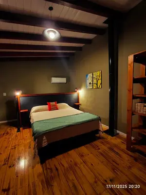 a bedroom with a bed and a wooden floor at Cabaña Ali in Villa Rumipal