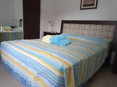 a bed with two blue towels on top of it at Terraza Carlos Paz in Villa Carlos Paz