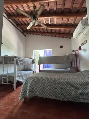 a bedroom with two beds and a ceiling fan at Las Tole - Potrero de Garay in La Estancia