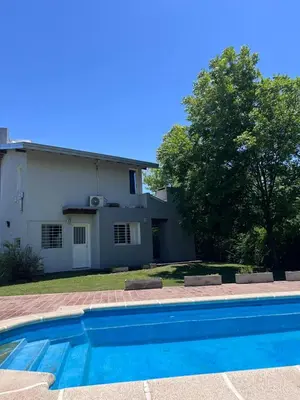 a swimming pool in front of a house at Las Tole - Potrero de Garay in La Estancia