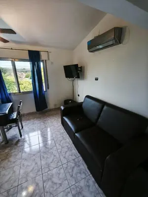 a living room with a black couch and a tv at Dpto Villa Carlos Paz max 5 personas in Villa Carlos Paz