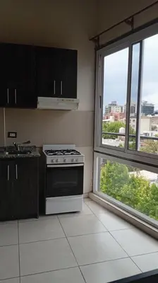 a kitchen with a stove and two windows at Sam Mira 1 in Villa Carlos Paz