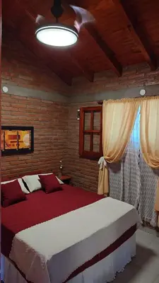a bedroom with a large bed and a ceiling at Complejo Terrazas de Cynthia in Mina Clavero