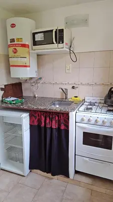 a kitchen with a sink and a stove at Complejo Terrazas de Cynthia in Mina Clavero