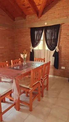 a dining room with a large wooden table and chairs at Complejo Terrazas de Cynthia in Mina Clavero