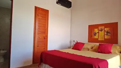 a bedroom with a bed with a red blanket at Complejo Terrazas de Cynthia in Mina Clavero