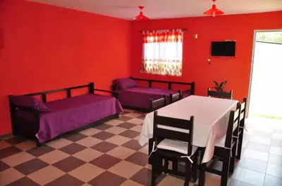 a bedroom with red walls and a table and a couch at Complejo Carola in Villa Carlos Paz