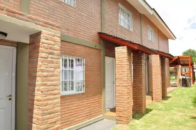 a brick building with a white door and windows at Complejo Carola in Villa Carlos Paz