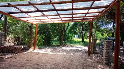 a wooden pergola in a yard with trees at Casa Megafó no in Las Rabonas