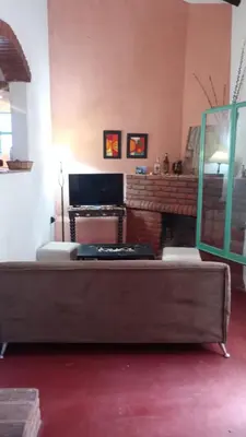 a living room with a table and a mirror at Casa Megafó no in Las Rabonas