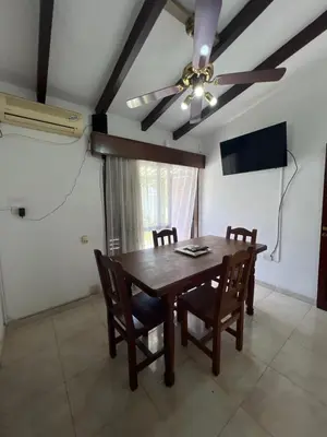 a dining room with a table and a ceiling fan at Casa céntrica in Villa Carlos Paz