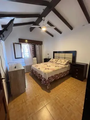 a bedroom with a bed and a ceiling fan at Casa céntrica in Villa Carlos Paz